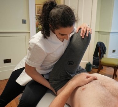 Specialist treating hip pain in male patient